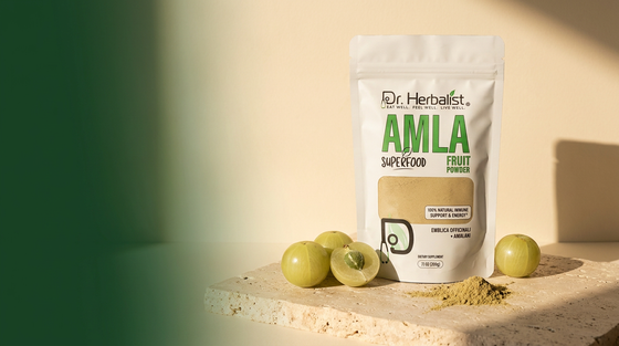 Dr. Herbalist Amla Powder pouch with fresh amla (Indian gooseberry) fruits on stone surface