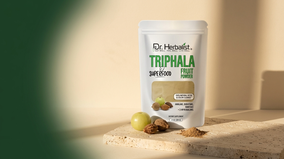 Dr. Herbalist Triphala Powder pouch with amla, haritaki and bibhitaki fruits on stone surface